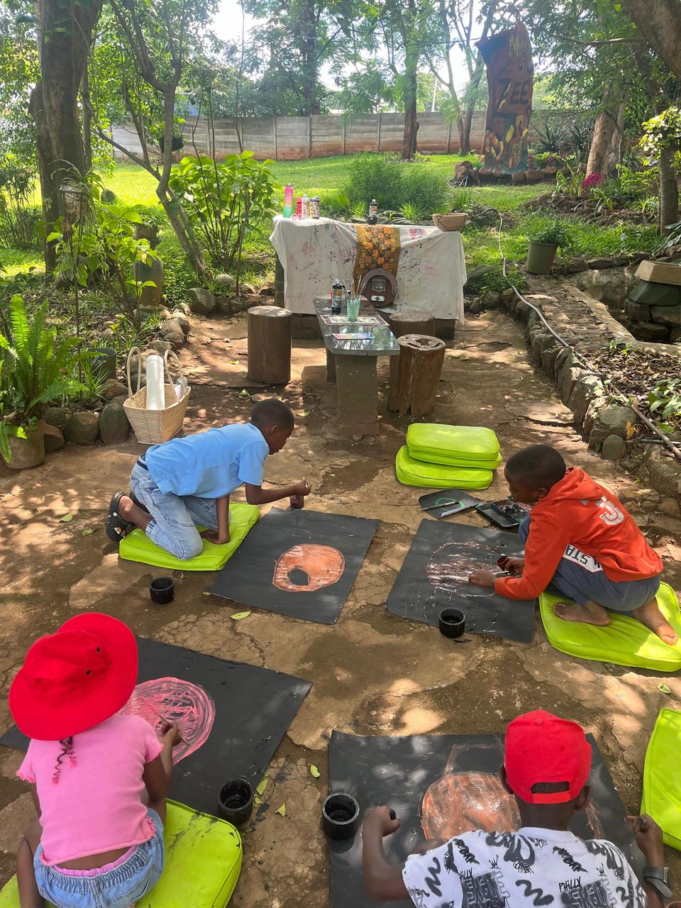 Children painting on cushions outdoors